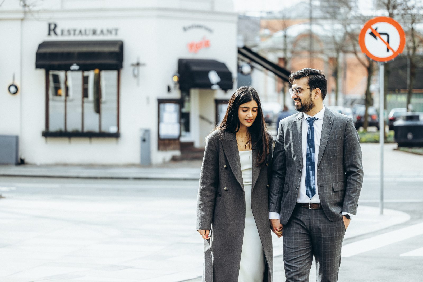 A candid, in-between moment as a couple cross a Copenhagen square, unaware of the camera