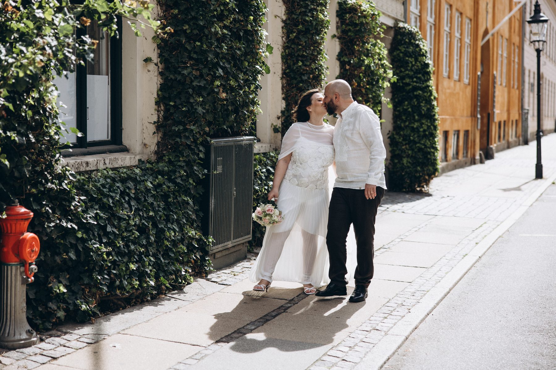 A couple kissing on an ivy-lined old street in Copenhagen