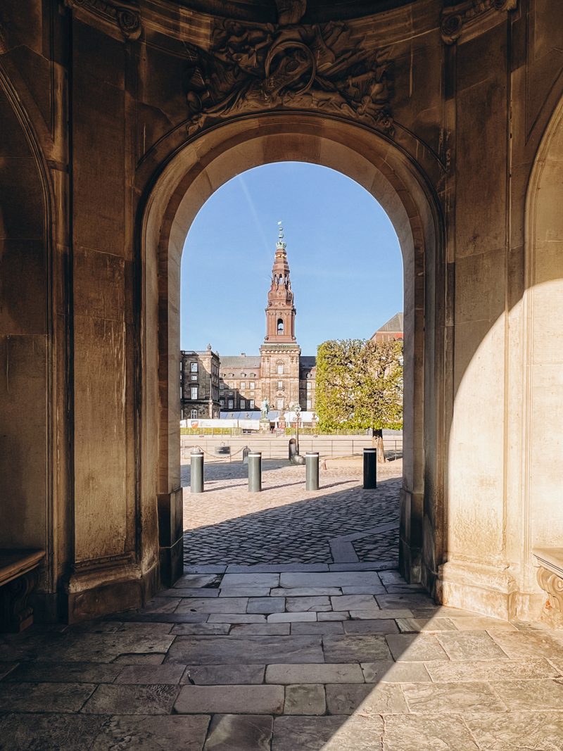 Christiansborg's spire framed by a stone archway