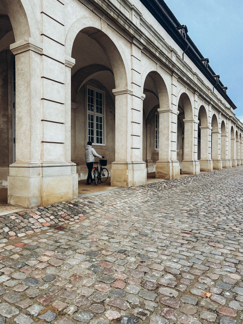 The arched colonnade and cobbles at Christiansborg