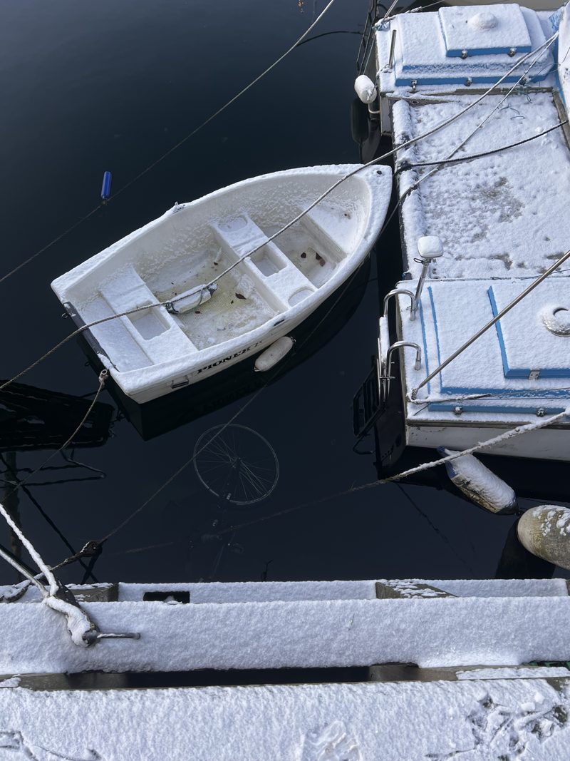 A white rowboat moored on the still canal, Christianshavn