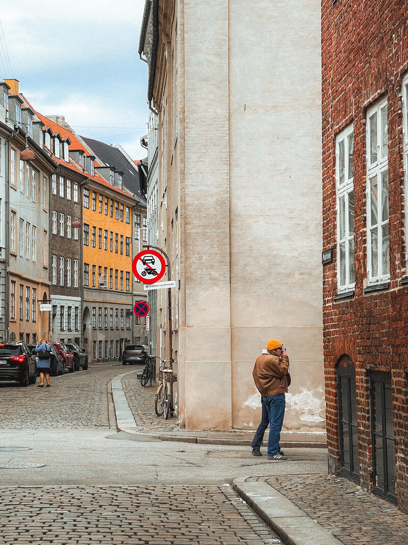 A figure pausing on a quiet corner of Magstræde