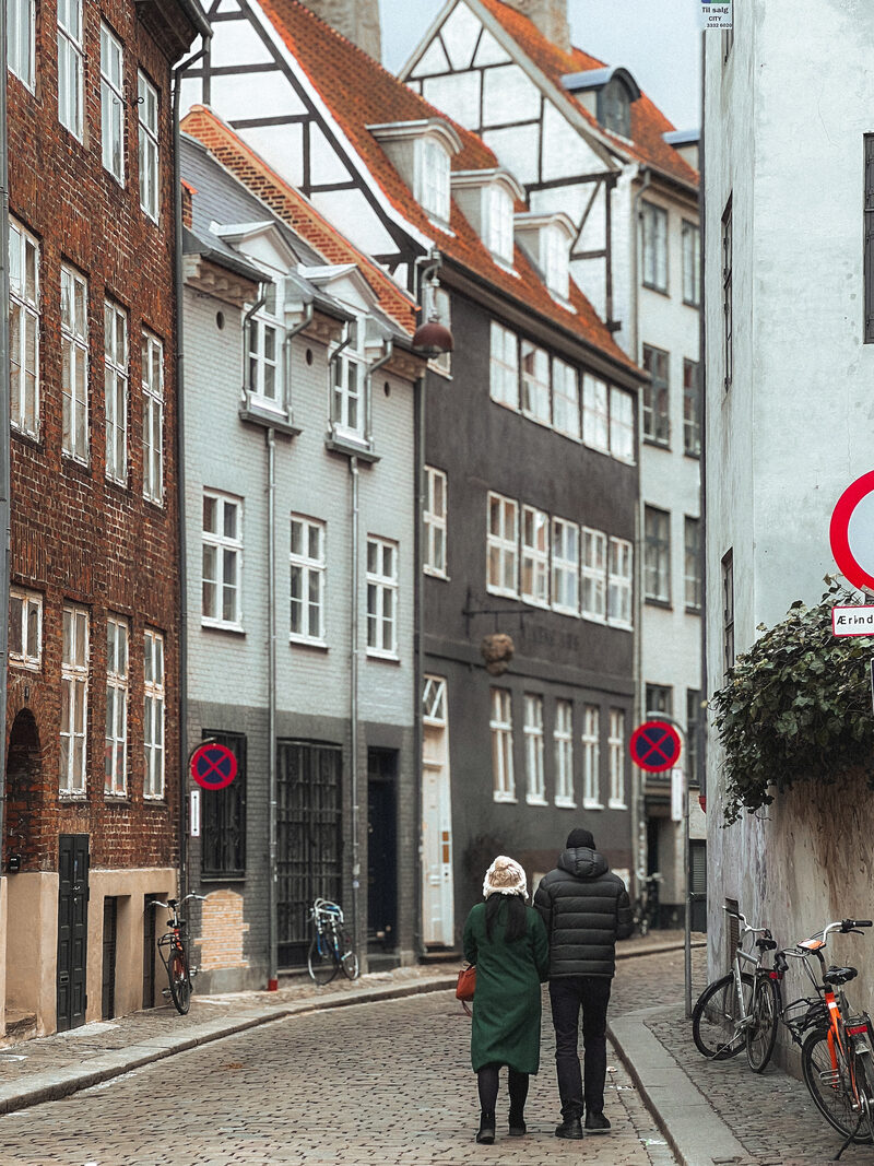 A couple walking away down cobbled Magstræde