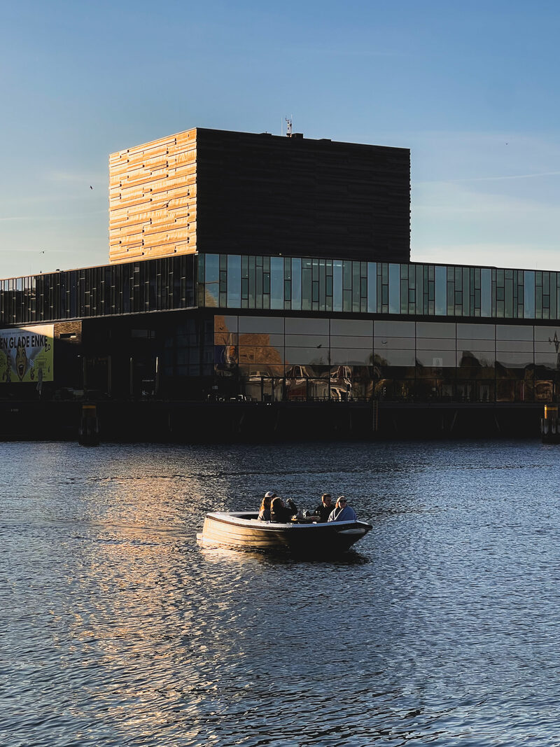 The Opera House at golden hour with a boat on the harbour