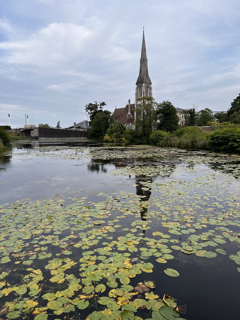 St Alban's Church across the lily pond under a dramatic sky