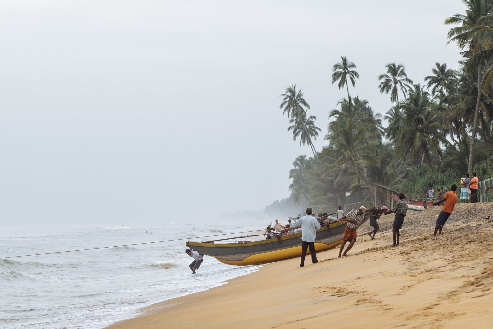 Fishermen pulling a boat ashore, Sri Lanka